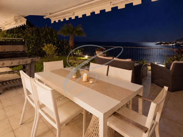 Terrasse d'un appartement avec vue sur la mer à Roquebrune-Cap-Martin, mobilier de jardin et barbecue.