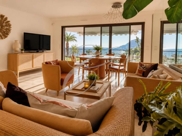 Intérieur d'un appartement moderne avec vue sur la mer, salon lumineux et mobilier contemporain.