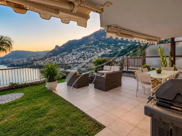Terrasse d'un appartement avec vue sur la baie de Monaco, mobilier de jardin et espace vert.
