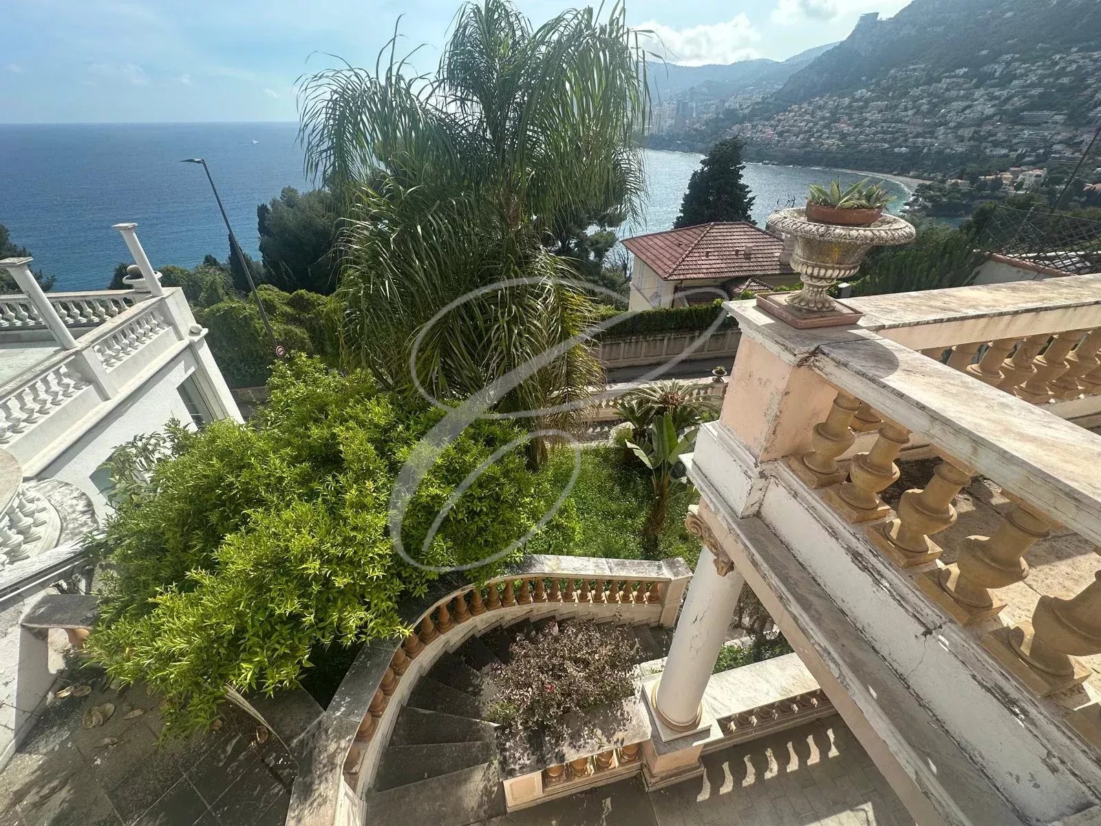 Property in Roquebrune-Cap-Martin View from a property in Roquebrune-Cap-Martin with stairs and vegetation, facing the sea.