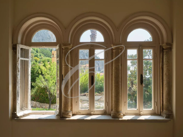 View from arched windows with an exotic garden in the background.