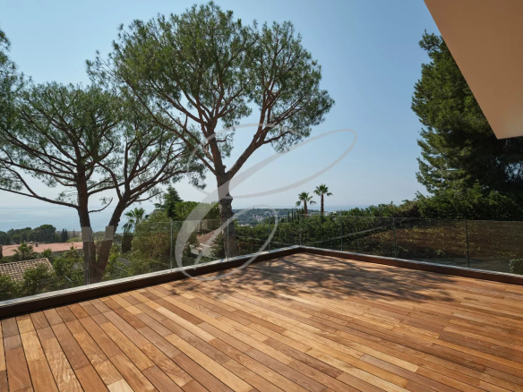 Terrasse en bois avec vue sur la mer et des arbres à Roquebrune-Cap-Martin.