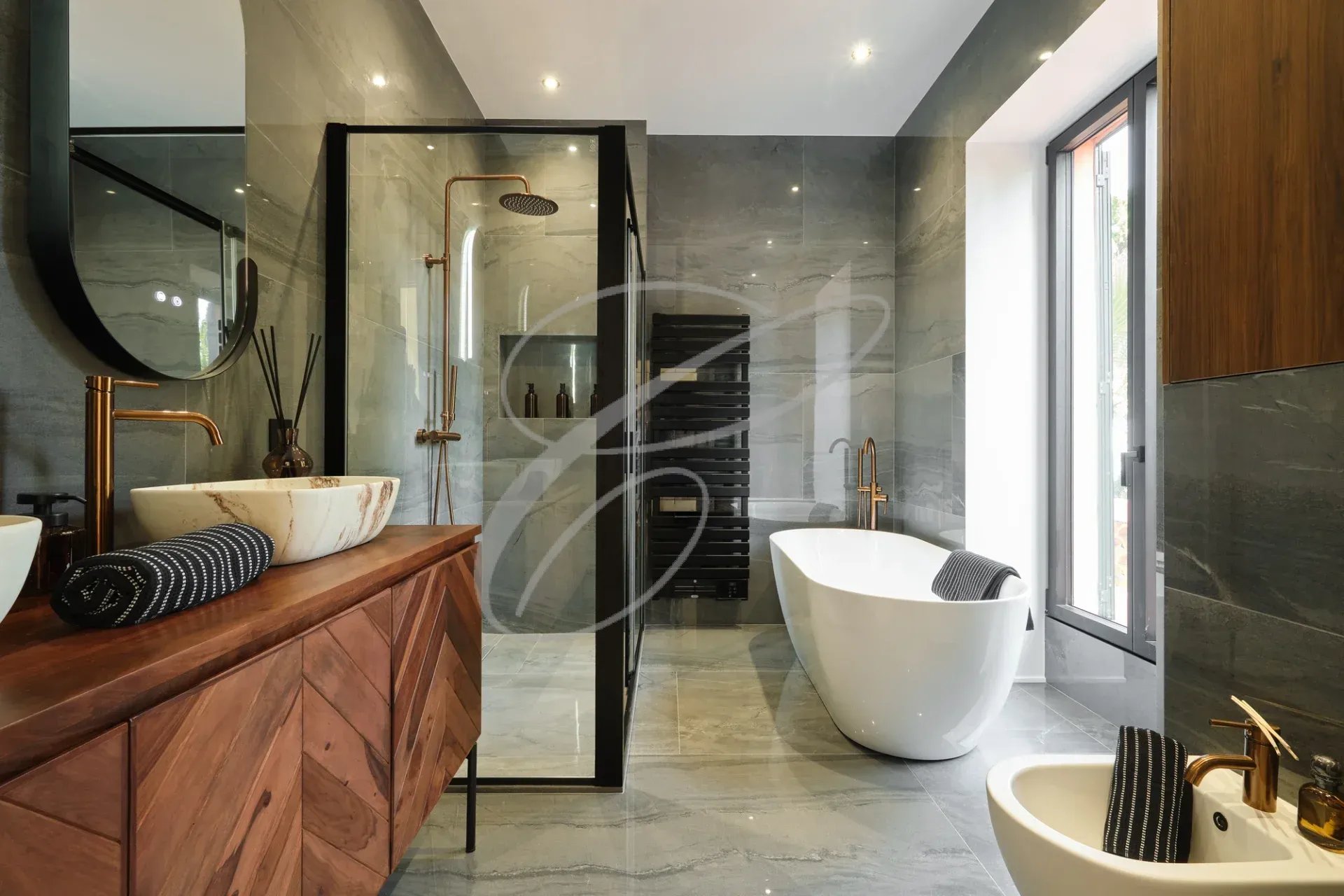 Salle de bain moderne avec baignoire, douche et meuble en bois.