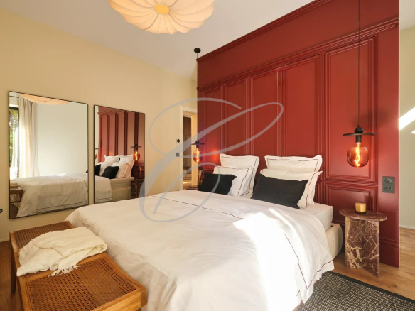 Chambre d'une propriété rénovée à Menton, avec lit double, miroir et décoration moderne.