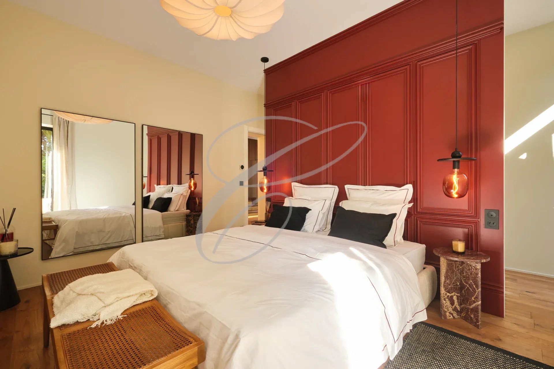 Chambre d'une propriété rénovée à Menton, avec lit double, miroir et décoration moderne.