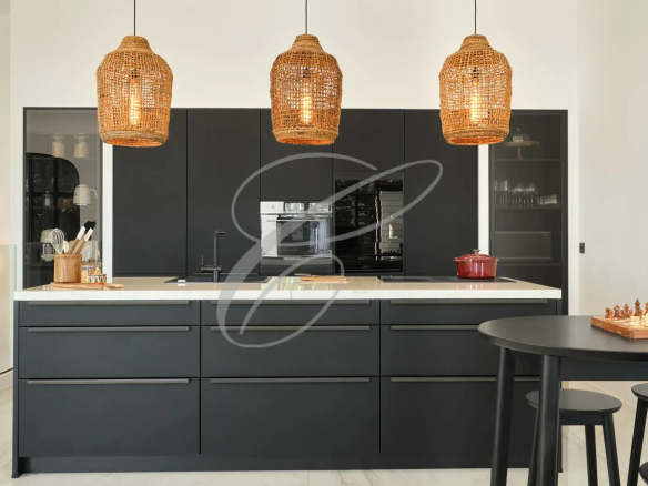 Cuisine moderne avec îlot central et luminaires en osier.