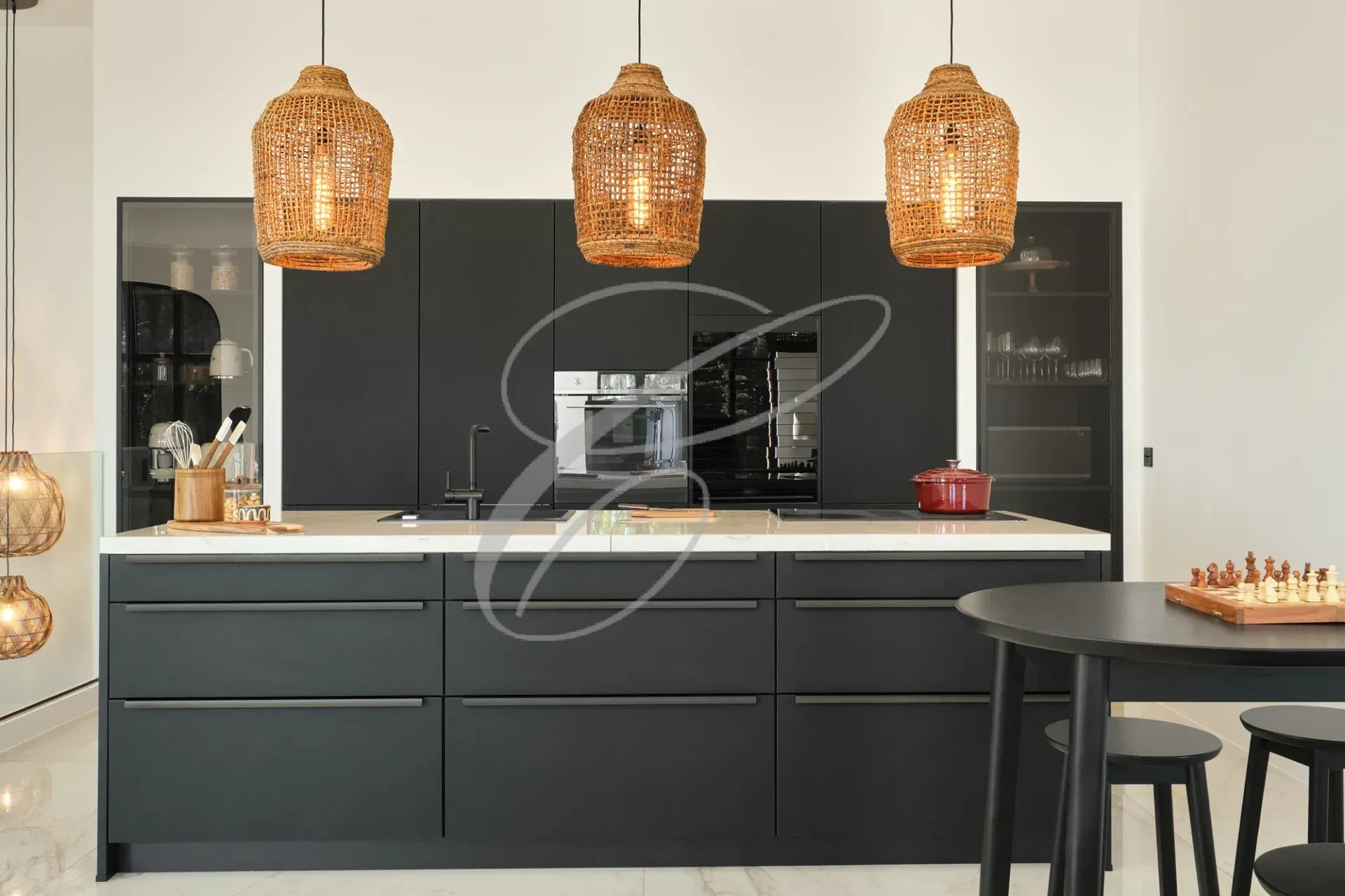 Cuisine moderne avec îlot central et luminaires en osier.