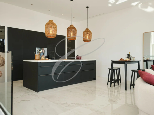 Cuisine moderne avec îlot central et éclairage suspendu en rotin.