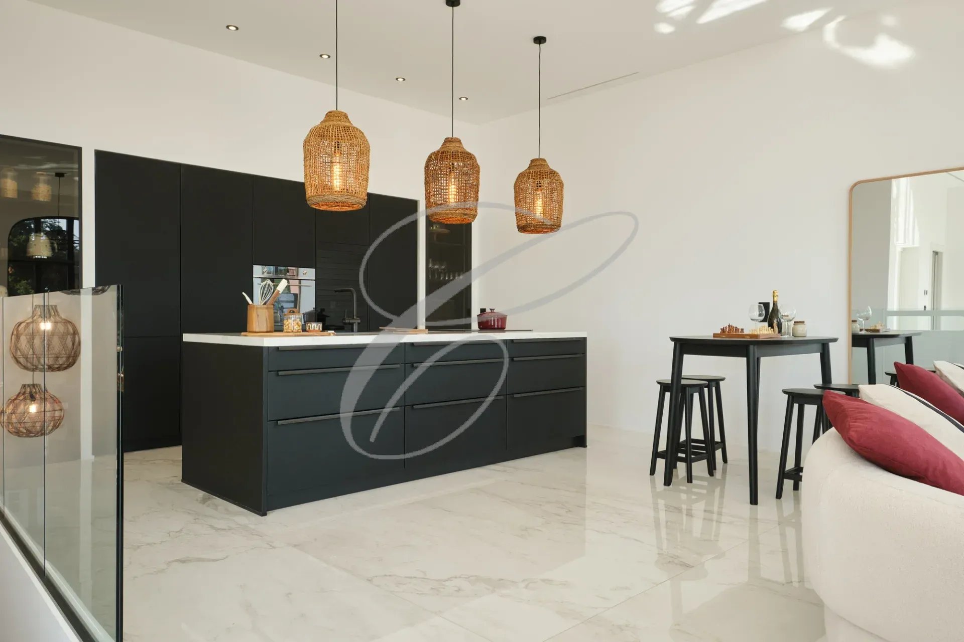 Cuisine moderne avec îlot central et éclairage suspendu en rotin.
