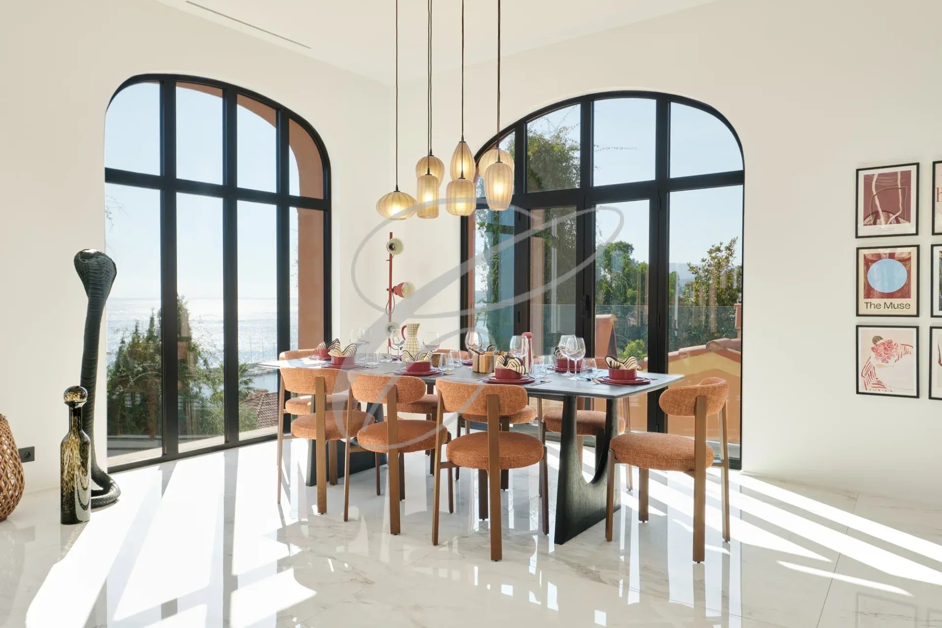 Salle à manger moderne avec vue sur la mer, grandes fenêtres et décoration élégante.
