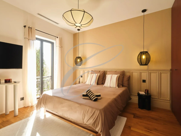 Chambre moderne avec lit double, télévision et balcon, décoration élégante.