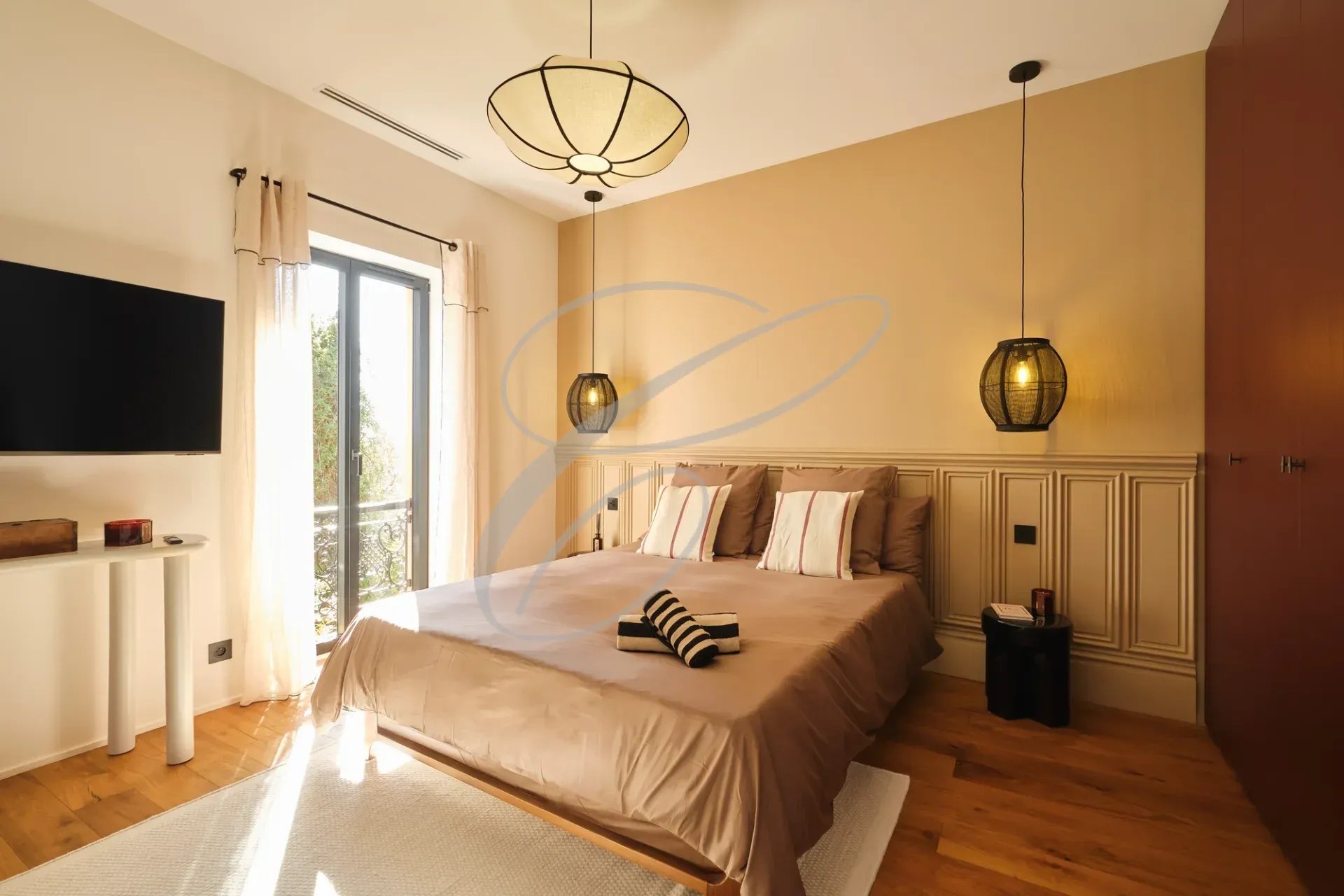 Chambre moderne avec lit double, télévision et balcon, décoration élégante.