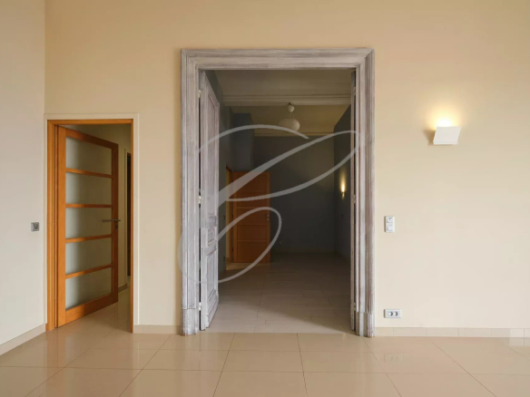 Intérieur d'un appartement spacieux à Beausoleil, avec un grand hall d'entrée et des murs clairs.