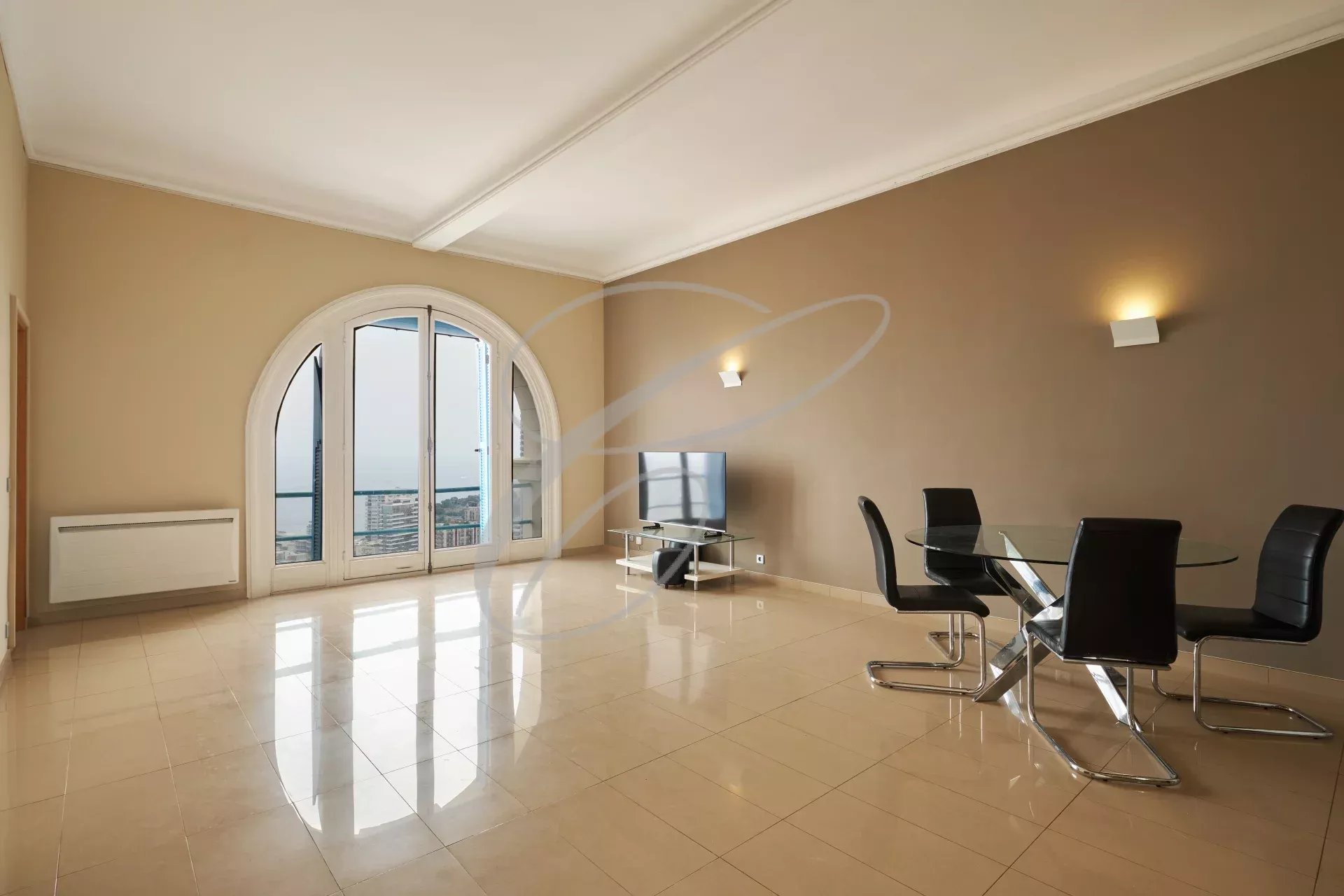 Intérieur d'un appartement spacieux avec vue sur la mer et Monaco, comprenant un séjour et une salle à manger.