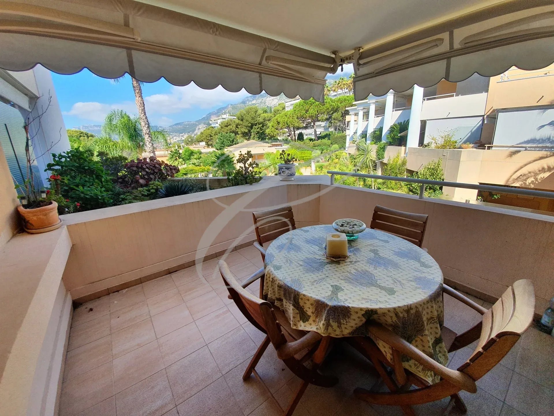 Terrace with garden view Apartment terrace with table and chairs, overlooking garden and park.