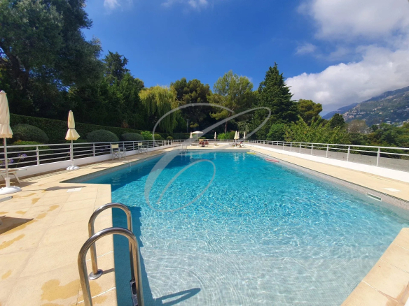 Swimming pool in a luxury residence in Roquebrune-Cap-Martin, surrounded by greenery.