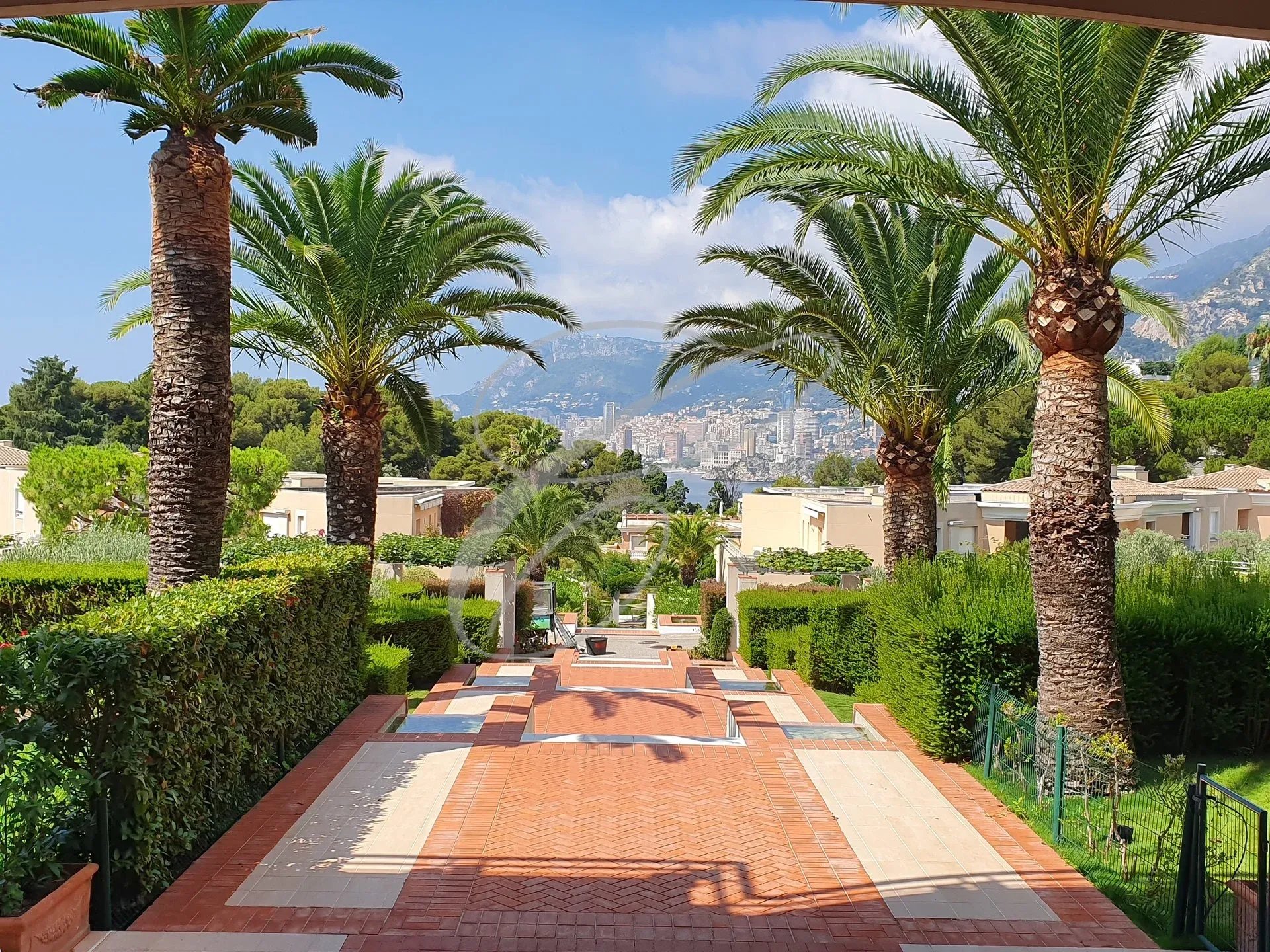 Alley with a view of Monaco Palm-lined walkway leading to a view of Monaco.