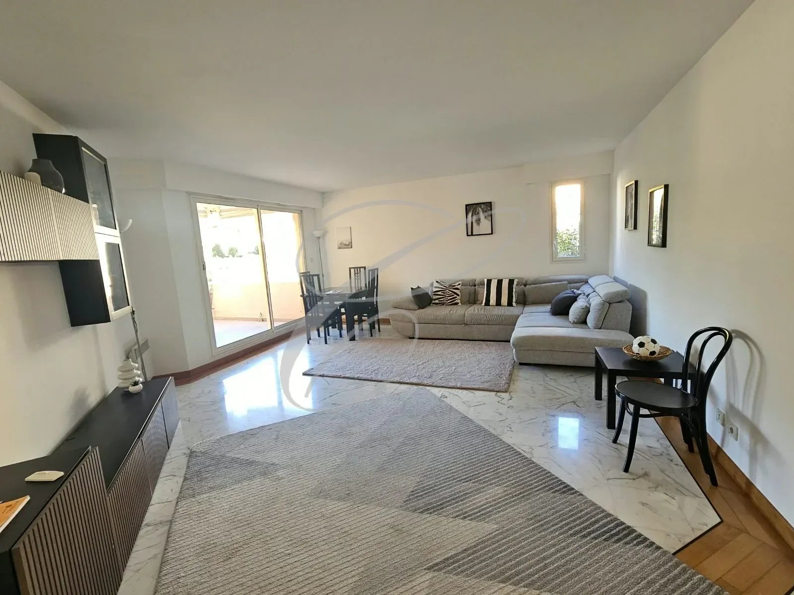 Living room of an apartment in Roquebrune-Cap-Martin Bright living room of an apartment with sofa, table and access to a terrace.