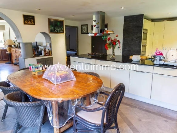 Modern kitchen with wooden table and chairs in a property in Cagnes-sur-Mer.