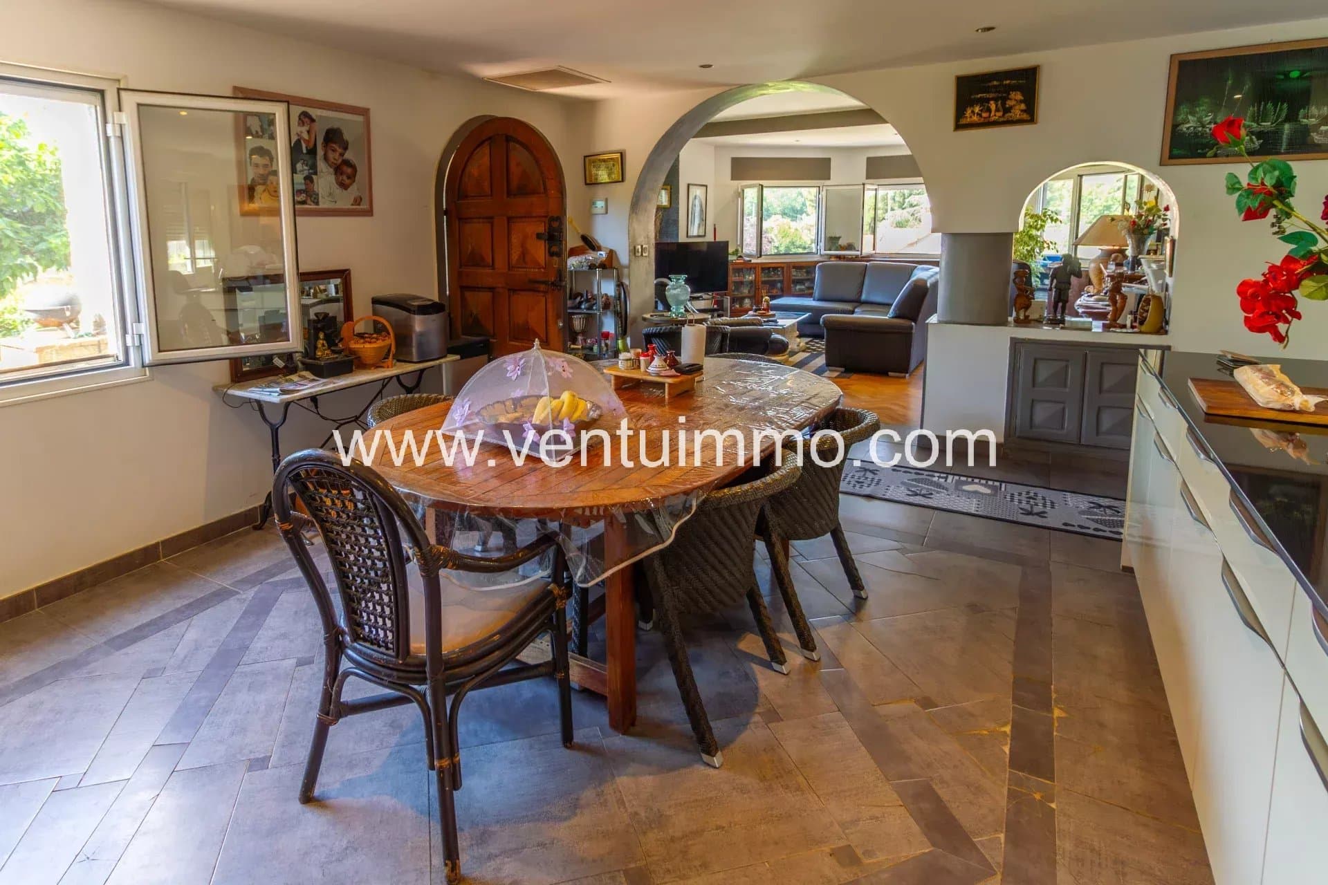 Interior of a property with a large wooden table and a bright living room in Cagnes-sur-Mer.