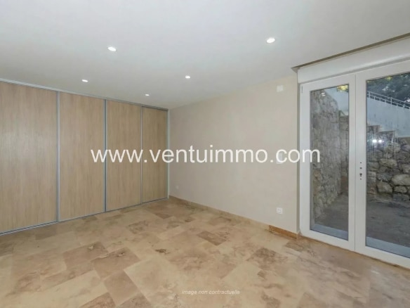 Interior of a terraced house in Mougins, with tiled floor and light-colored walls.