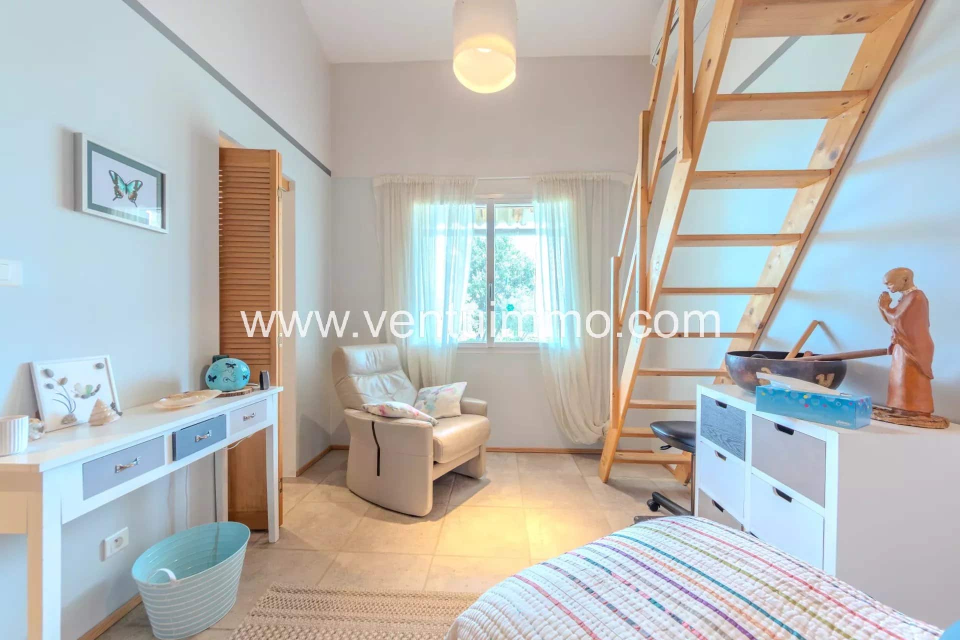 Intérieur d'une maison avec un coin salon et un escalier en bois.