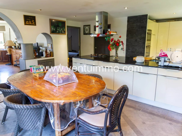 Intérieur d'une cuisine moderne avec table en bois et chaises en rotin.