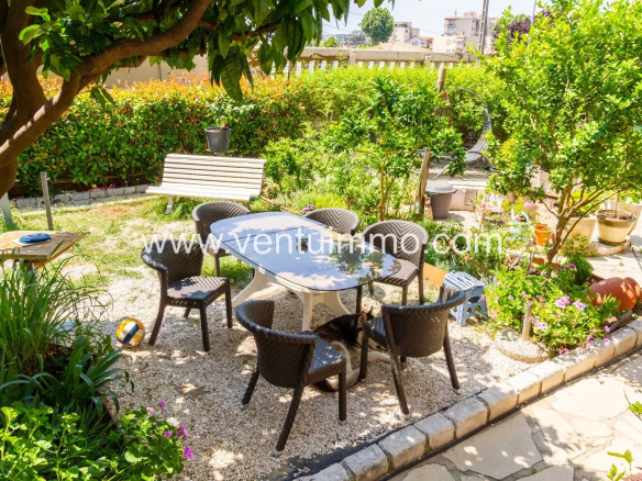 Jardin avec table et chaises, entouré de verdure à Cagnes-sur-Mer.