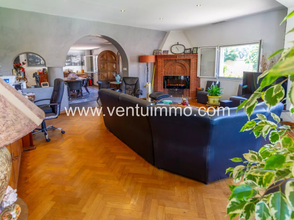 Intérieur d'une propriété familiale à Cagnes-sur-Mer avec un salon spacieux et des fauteuils.