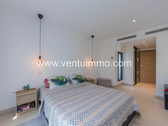 Chambre d'une villa contemporaine à Cannes La Bocca avec lit et décoration moderne.