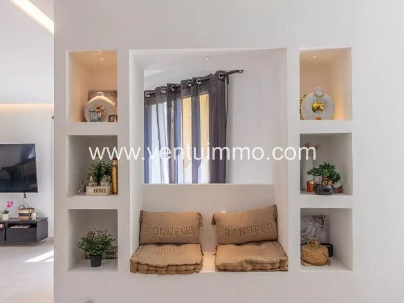Intérieur d'une villa contemporaine avec des niches décoratives et un coin salon confortable.