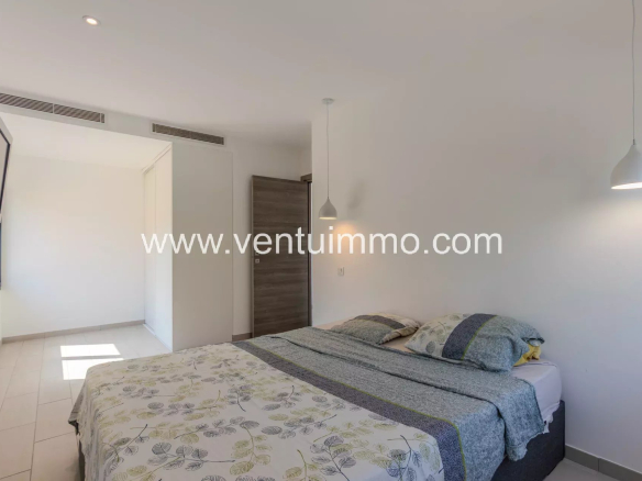Chambre d'une villa contemporaine avec lit double et décoration moderne.