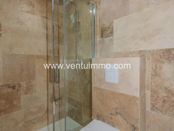 Salle de bain moderne avec douche en verre et carrelage en marbre