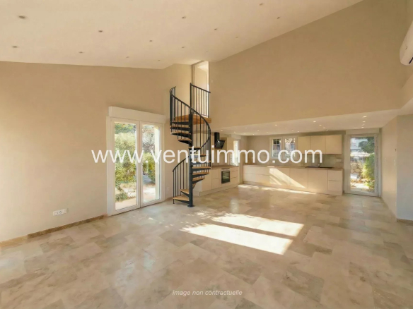 Intérieur d'une maison mitoyenne à Mougins, avec un escalier en colimaçon et un espace lumineux.
