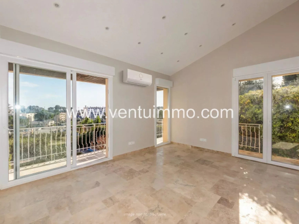 Intérieur d'une maison mitoyenne à Mougins avec fenêtres ouvertes sur un balcon.
