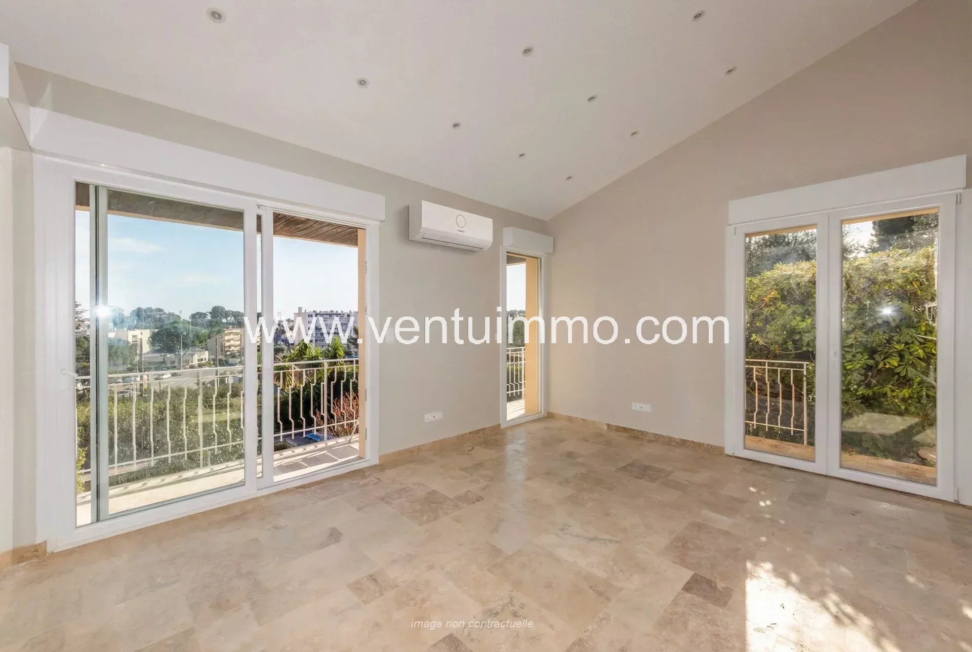 Intérieur d'une maison mitoyenne à Mougins avec fenêtres ouvertes sur un balcon.