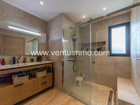 Salle de bain moderne avec douche en verre et meuble en bois