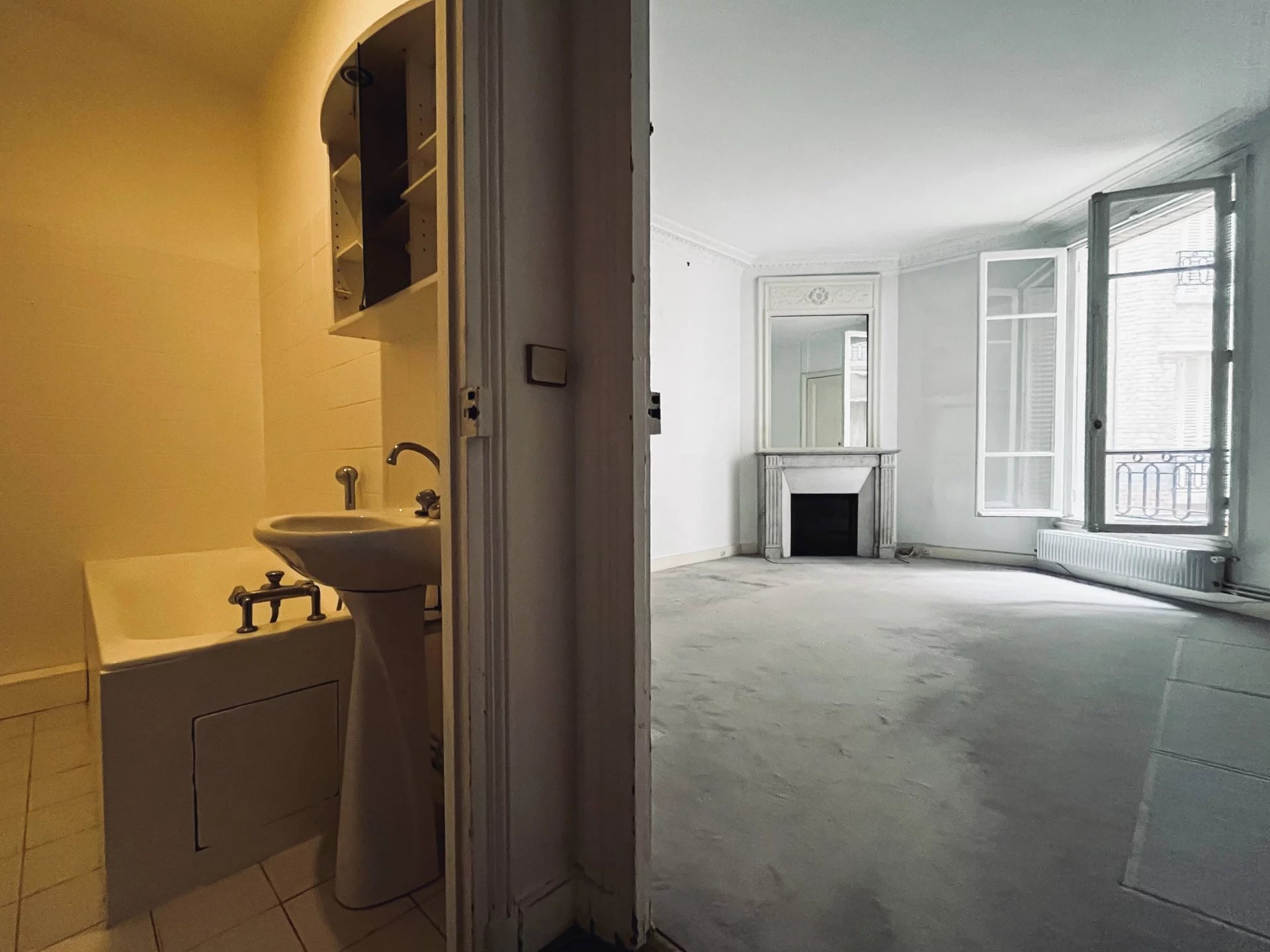 Appartement familial à rénover à Neuilly-sur-Seine Intérieur d'un appartement à rénover avec baignoire et espace séjour à Neuilly-sur-Seine.