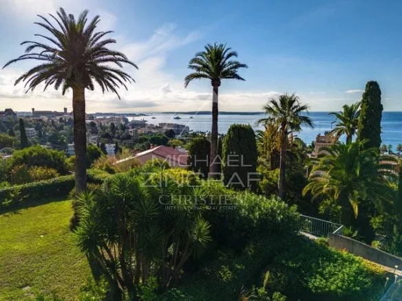 Vue panoramique sur la mer et la végétation depuis un jardin à Cannes.