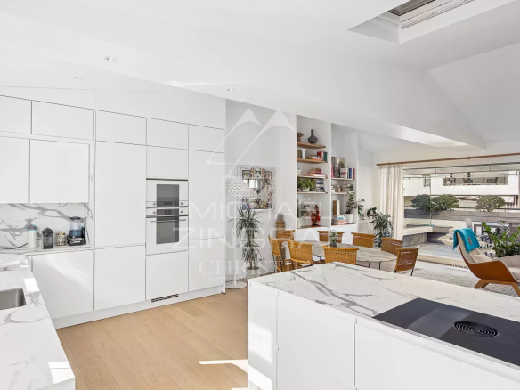 Cuisine moderne et lumineuse avec vue sur la terrasse dans un appartement à Cannes.