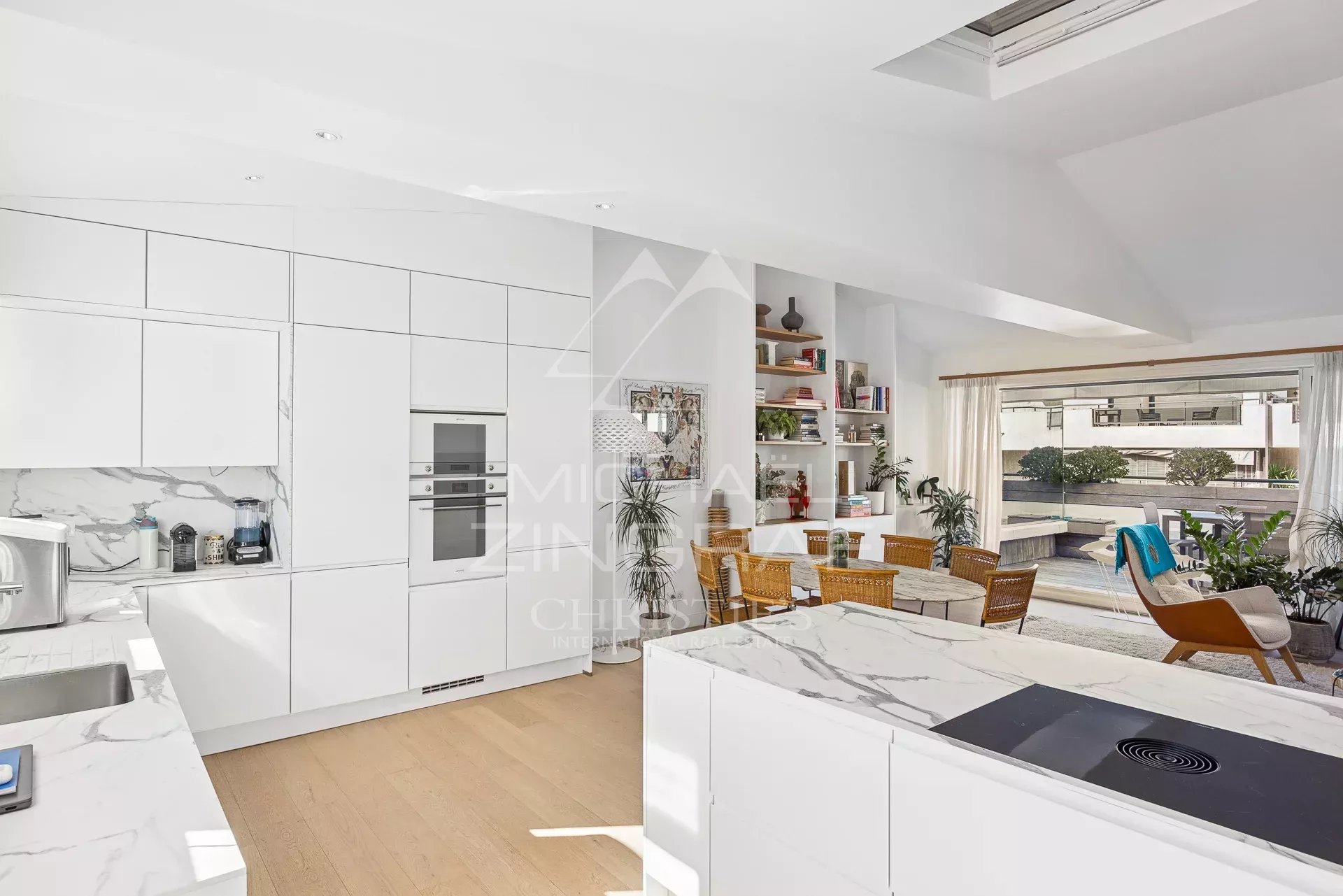 Cuisine moderne et lumineuse avec vue sur la terrasse dans un appartement à Cannes.