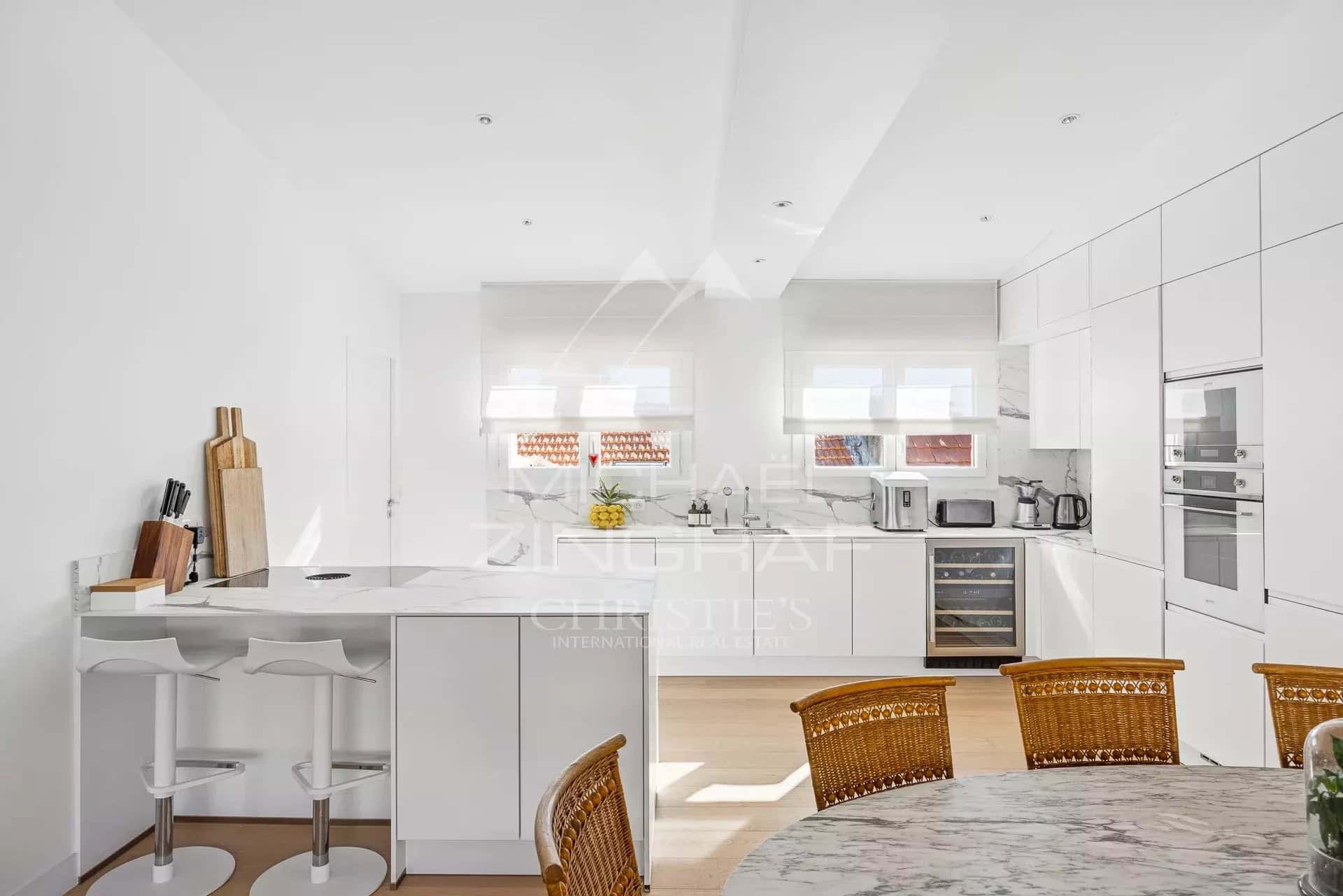 Cuisine moderne avec bar et table à manger dans un appartement à Cannes.