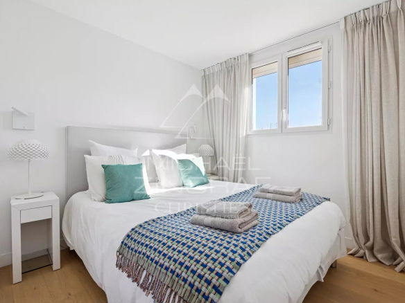 Chambre d'un appartement moderne à Cannes avec lit double et décoration épurée.