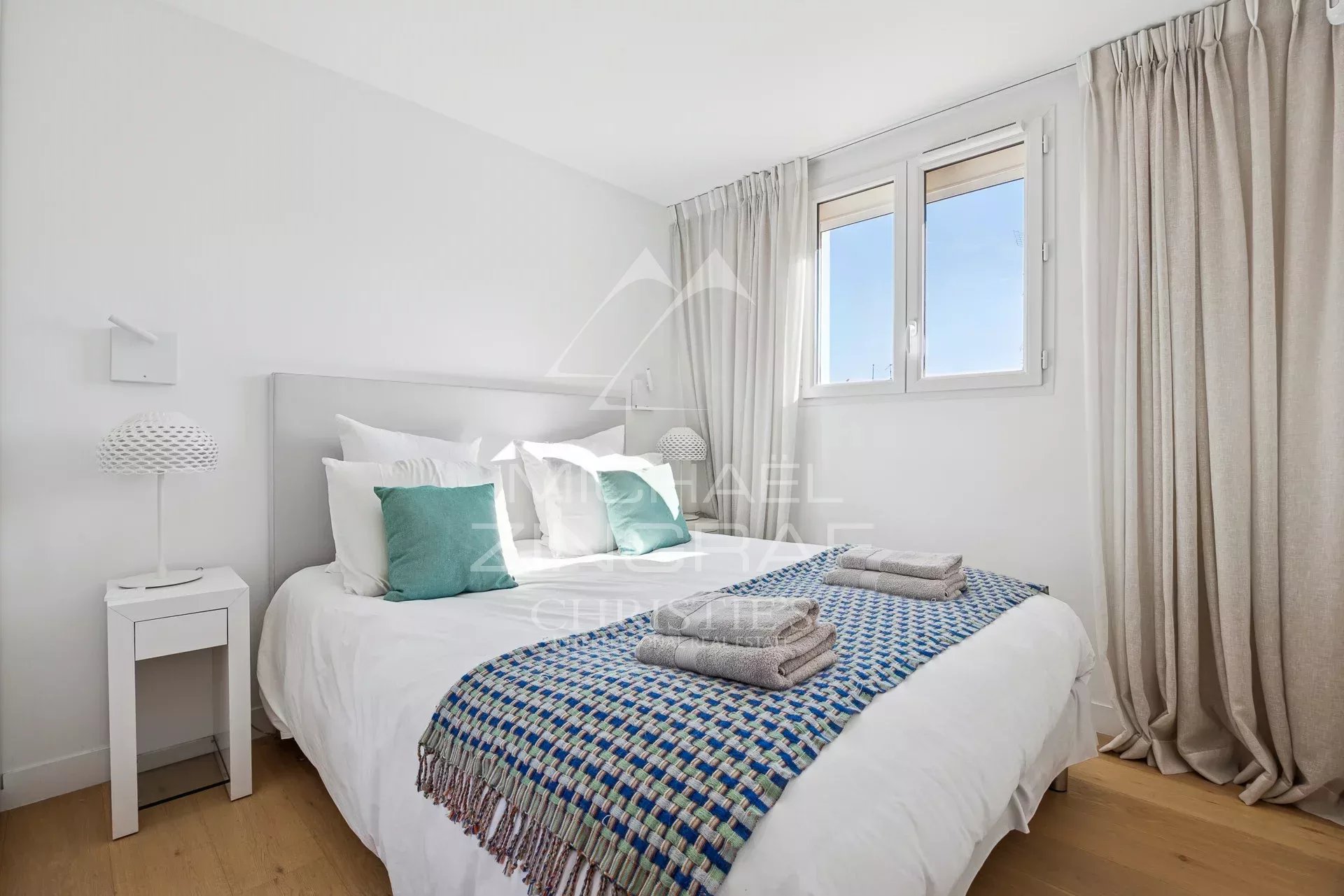 Chambre d'un appartement moderne à Cannes avec lit double et décoration épurée.