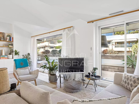 Salon lumineux d'un appartement à Cannes avec terrasse, décor moderne et plantes.