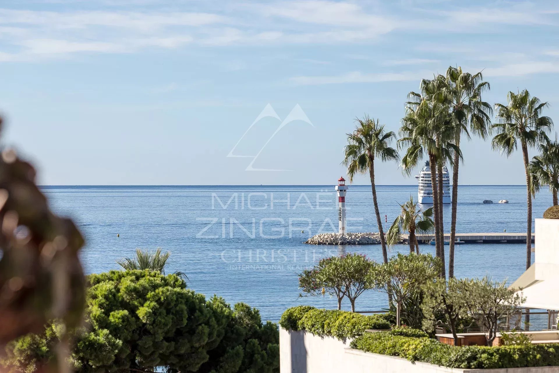 Vue sur la mer et les palmiers depuis un penthouse à Cannes.