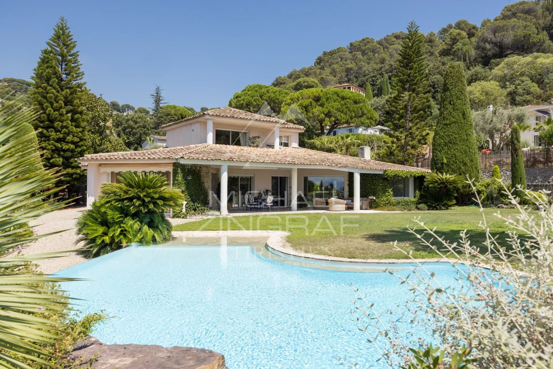 Modern property with swimming pool and sea view in Cannes, surrounded by greenery.