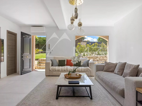 Modern living room with sofa and coffee table, overlooking a green garden in Vallauris.