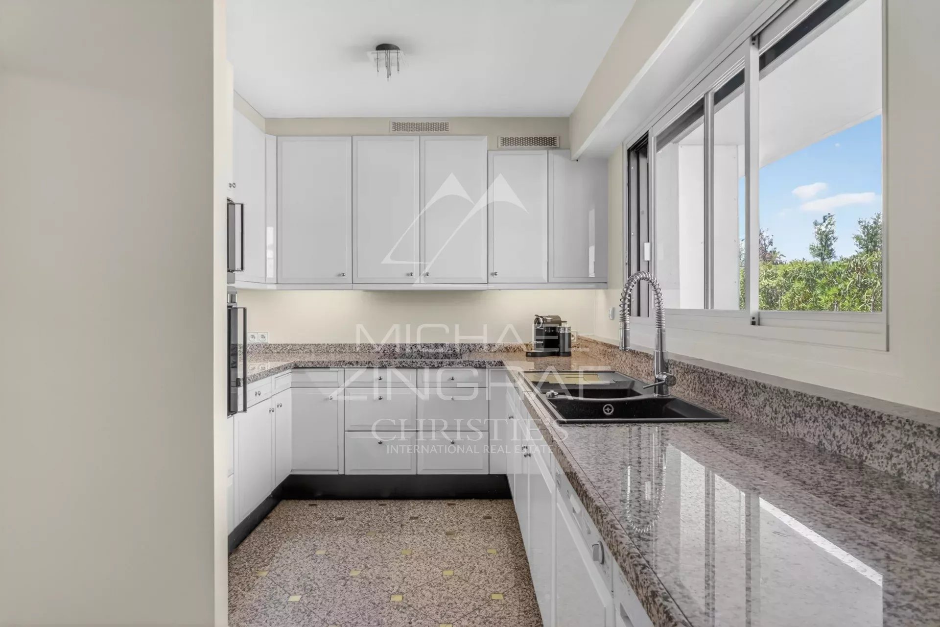 Spacious and bright kitchen in a Cannes penthouse with granite worktops.
