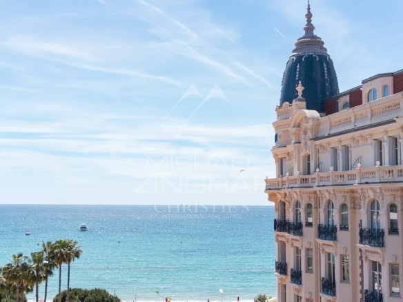 Sea view from a building in Cannes, with palm trees in the foreground.